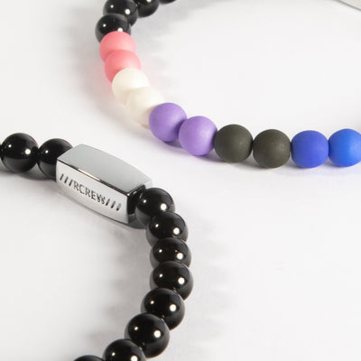 Close-up of genderfluid pride bracelet showing pink, white, purple, black and blue beads and RCREW clasp, 6mm