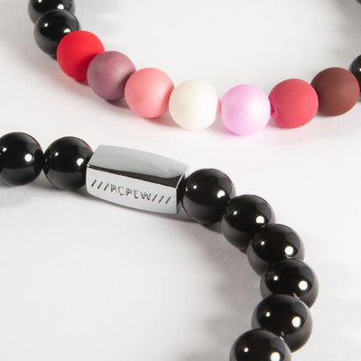 Close-up of lesbian pride bracelet showing red, pink and white beads and RCREW clasp, 8mm