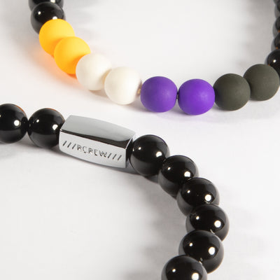 Close-up of non-binary pride bracelet showing yellow, white, purple and black beads and RCREW clasp, 8mm
