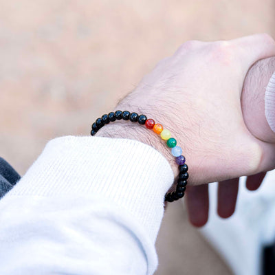 Close-up of semi-precious rainbow pride bracelet on a wrist, highlighting gemstone detail