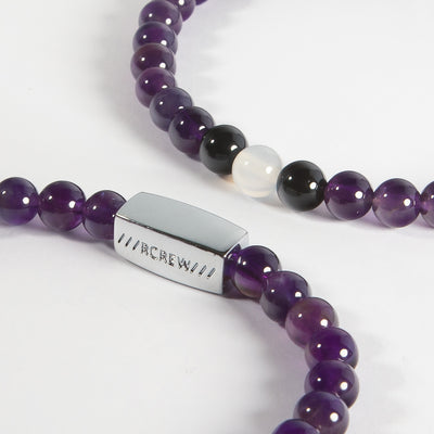 Close-up of labrys lesbian pride bracelet showing black and violet gemstone beads and RCREW clasp, 6mm