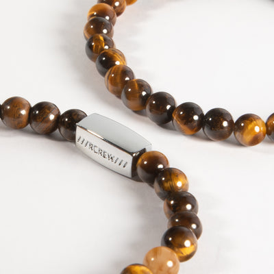 Close-up of tiger's eye semi-precious bracelet showing natural gemstone beads and RCREW clasp, 6mm