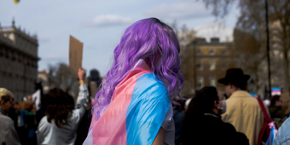 Trans woman wearing flag at a protest (Credit: Karollyne Videira Hubert)