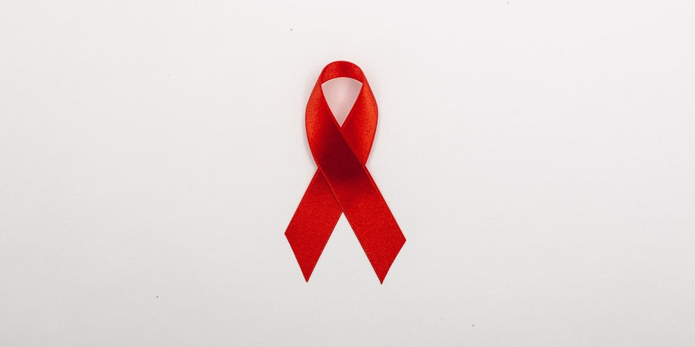 A red AIDS ribbon on a white background