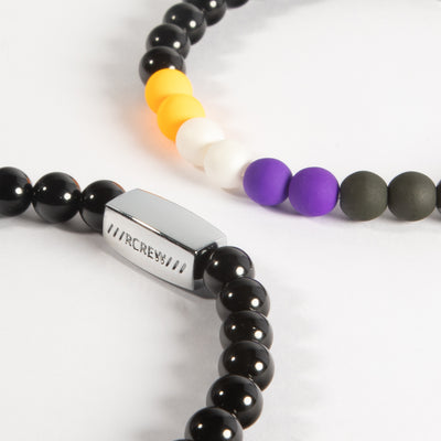 Close-up of non-binary pride bracelet showing yellow, white, purple and black beads and RCREW clasp, 6mm