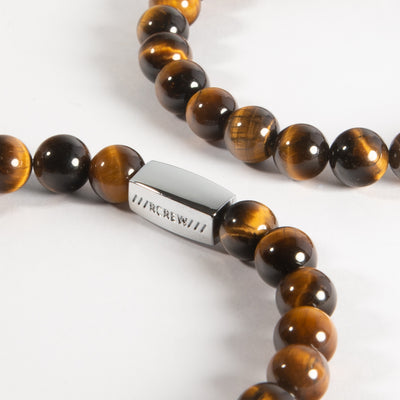 Close-up of tiger's eye semi-precious bracelet showing natural gemstone beads and RCREW clasp, 8mm